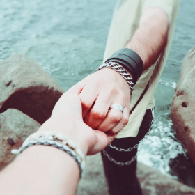 A hand reaching for and grasping another hand