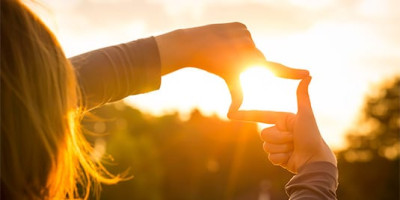 woman surrounding the sun with her hands