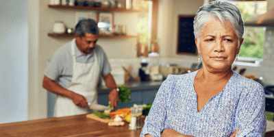 Wife clearly angry while husband is cooking in the background