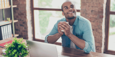man looking up and smiling while holding coffee