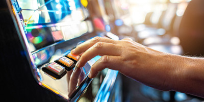 hand pushing gambling slot machine button