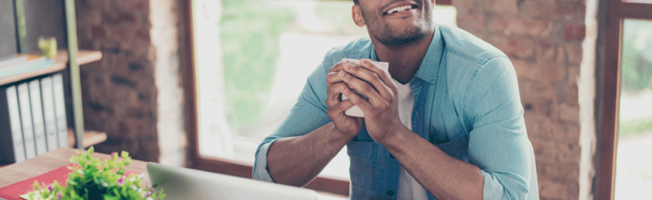 man looking up and smiling while holding coffee