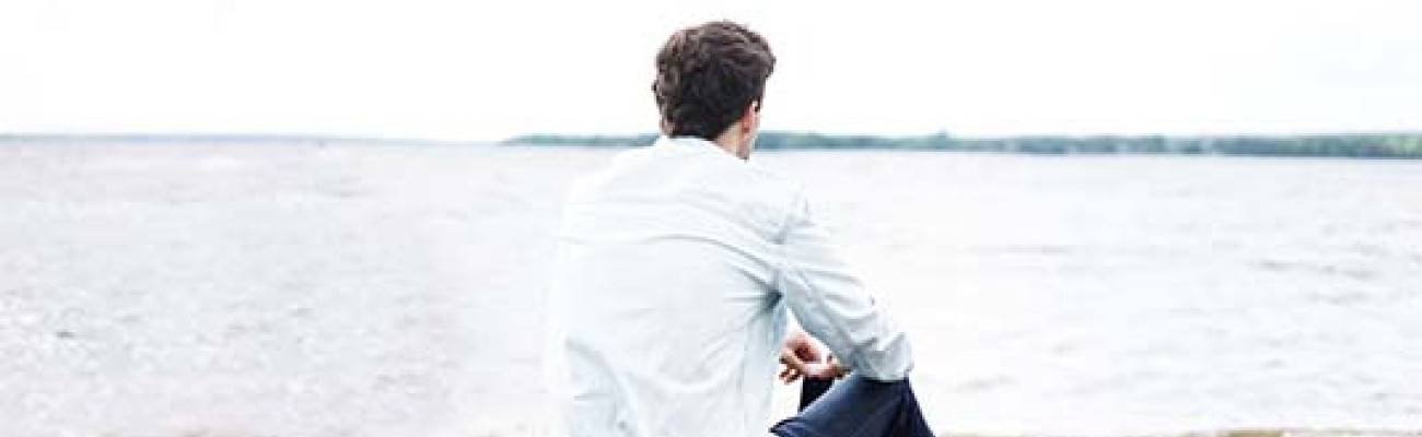 man on the beach looking at the ocean