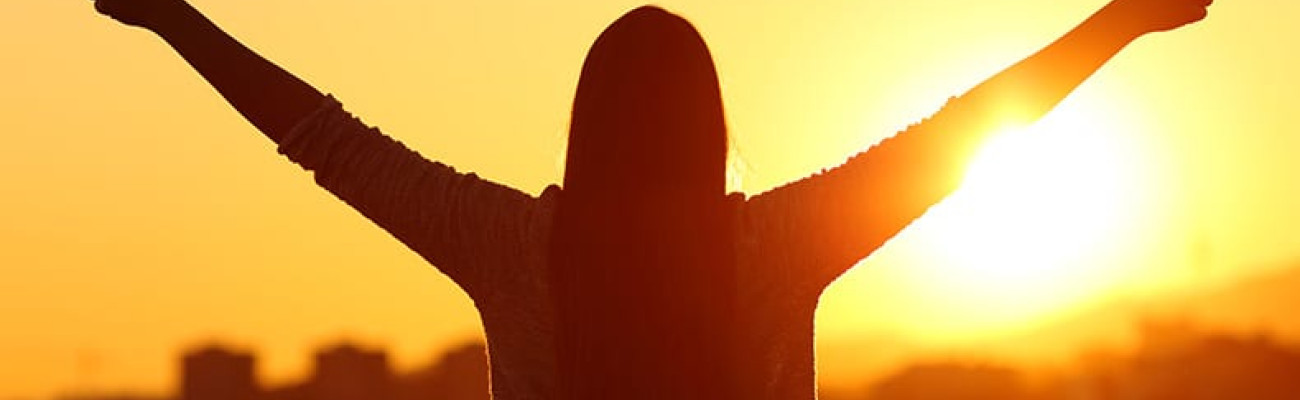 female outline in the sun with both thumbs up