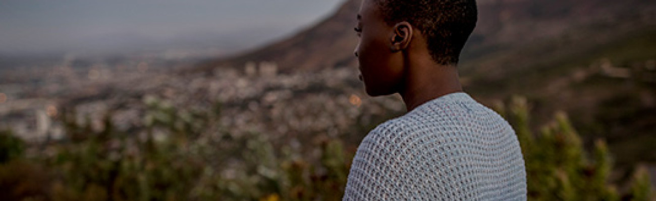 woman on a mountain looking down at the view below