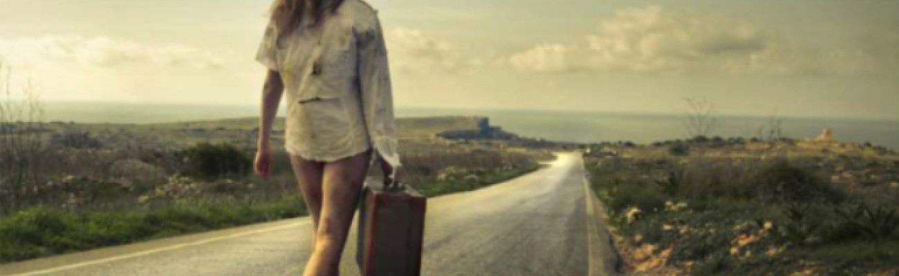 woman walking on the road with a suitcase